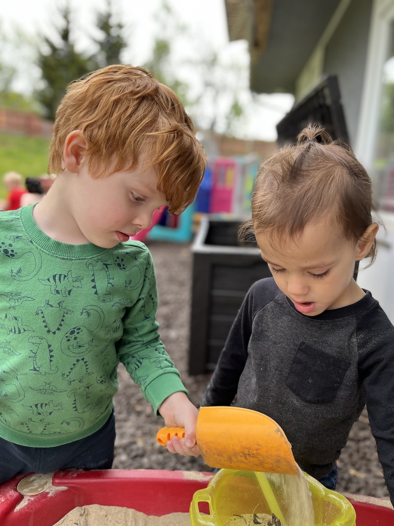 Boys playing in the sandbox.